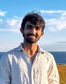 Abhinav Bolla, smiling, by the sea